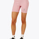 Woman wearing the Osaka women tech short thights in pink with grey logo. Front view