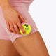 Woman wearing the Osaka women tech short thights in pink with grey logo. Front detail pocket view