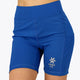 Woman wearing the Osaka women tech short thights in princess blue with grey logo. Front view