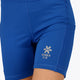 Woman wearing the Osaka women tech short thights in princess blue with grey logo. Front detail logo view