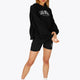 Woman wearing the Osaka women tech short thights in black with grey logo. Front view