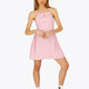 Woman wearing the Osaka women pleated tech dress in pink with grey logo. Front view