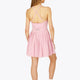 Woman wearing the Osaka women pleated tech dress in pink with grey logo. Back view
