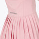 Woman wearing the Osaka women pleated tech dress in pink with grey logo. Back detail logo view