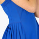 Woman wearing the Osaka women pleated tech dress in princess blue with grey logo. Side detail view