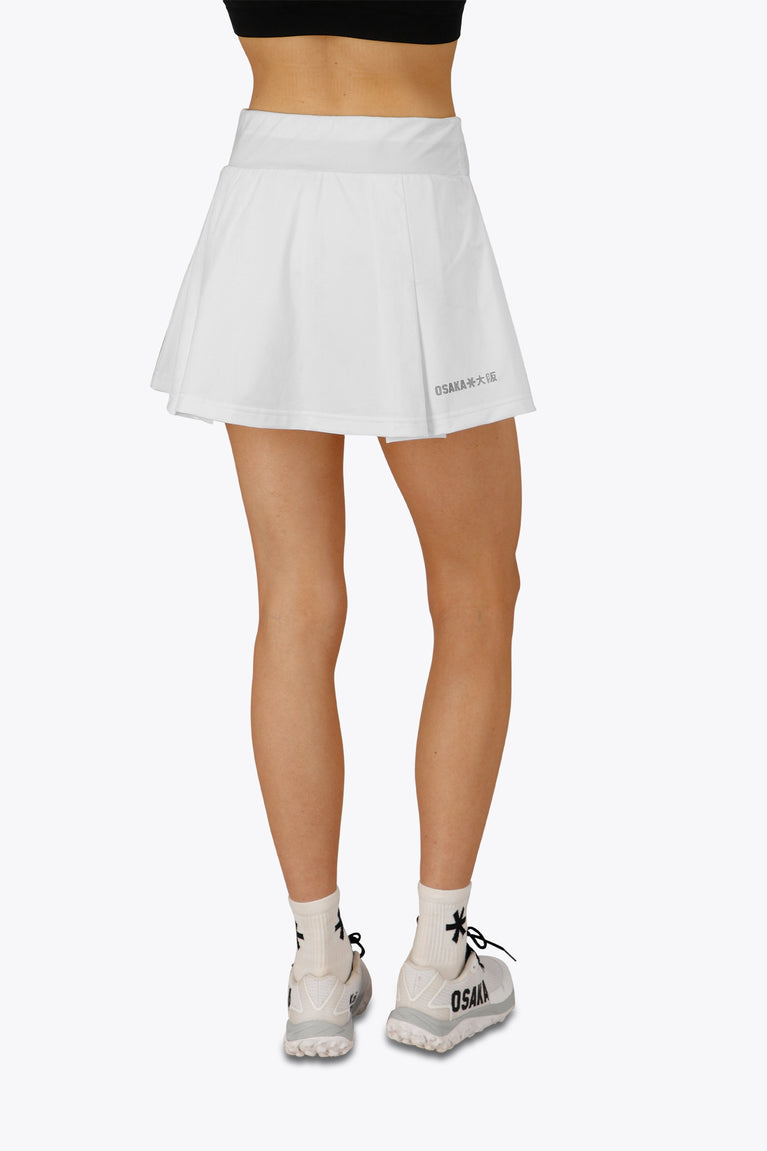 Woman wearing the Osaka women floucy skort white with logo in grey. Back view