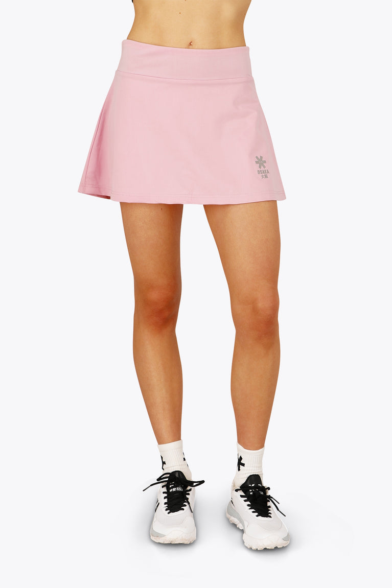 Woman wearing the Osaka women floucy skort pink with logo in grey. Front view