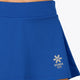 Woman wearing the Osaka women floucy skort princess blue with logo in grey. Front detail logo view