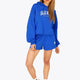 Woman wearing the Osaka women cropped hoodie inprincess blue with college logo in white. Front view