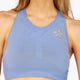 Woman wearing the Osaka women tech sports bra in manor blue with logo in grey. Front detail logo view
