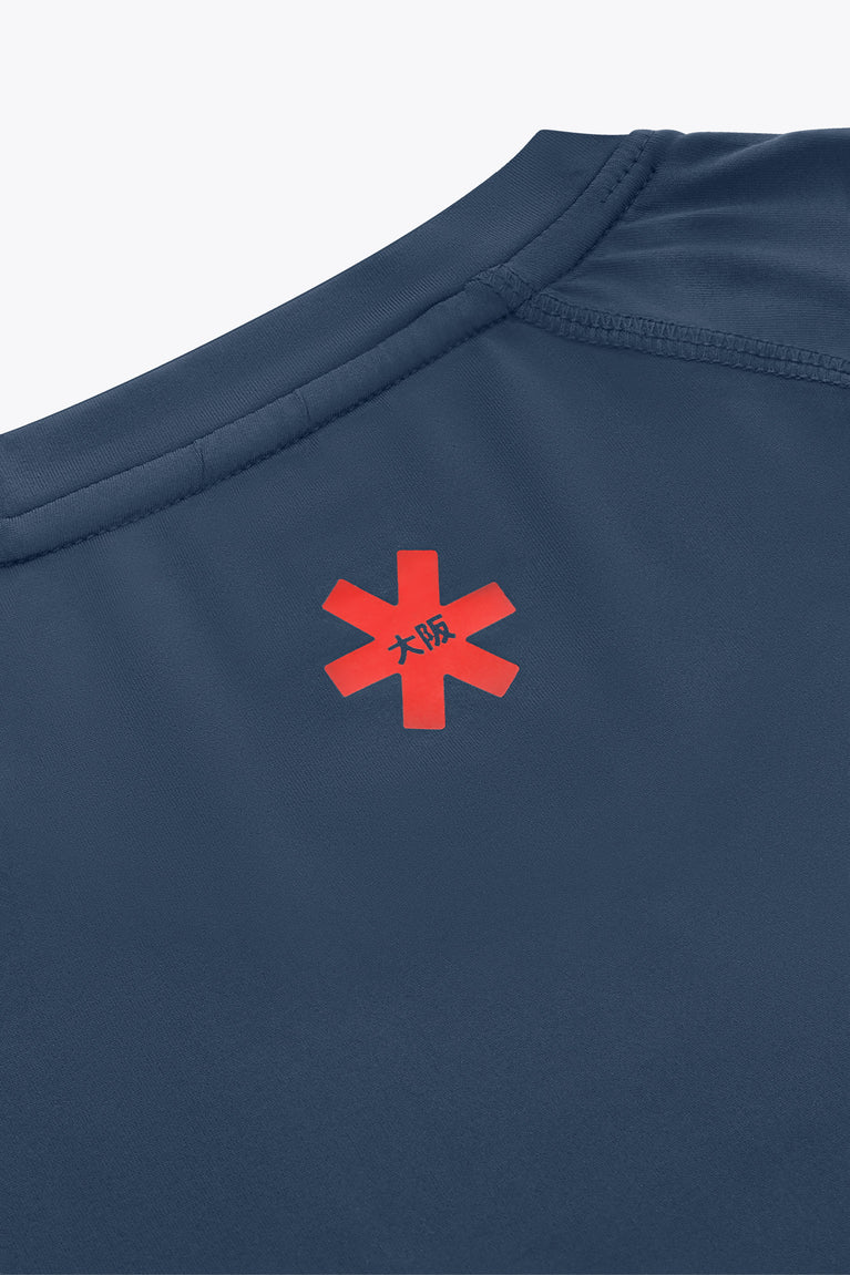 Dark blue long-sleeve tee showing back emblem with red cross graphic