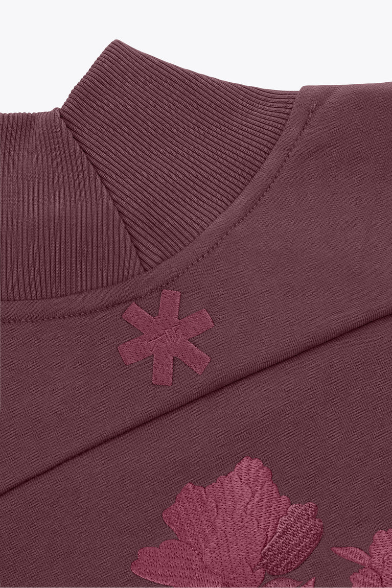 Women’s mockneck sweater shoulder close-up with ribbed collar and snowflake patch