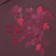 Women’s mockneck sweater close-up of red floral applique on dark plum fabric