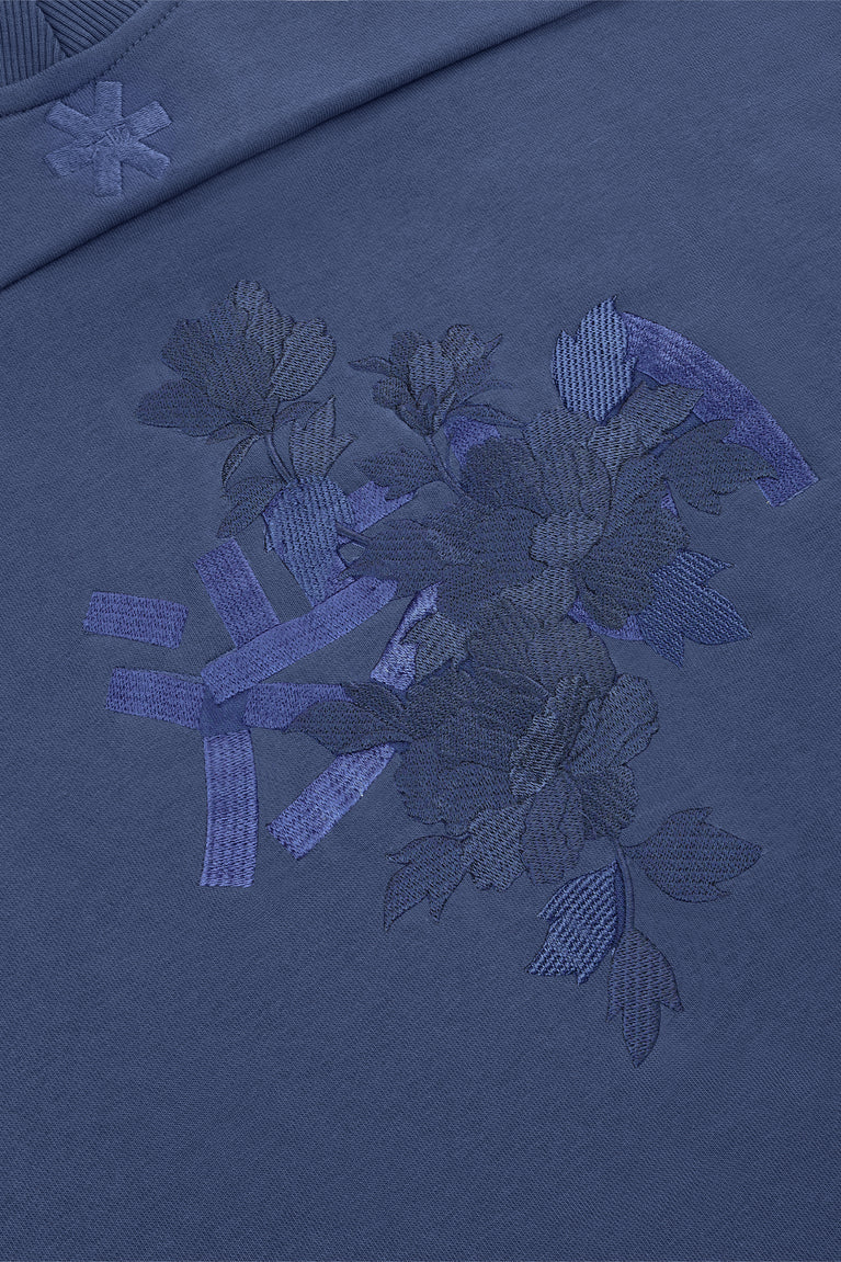 Blue mockneck sweater with raised embroidered floral and snowflake patch