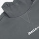 Dark grey melange mockneck sweater with embroidered OSKA* detail and stitched collar seam.