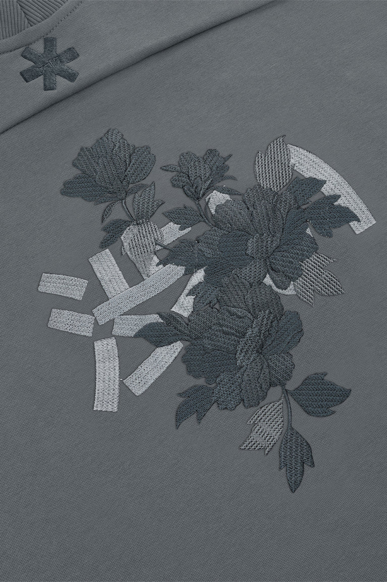 Dark grey melange sweater with large floral embroidery and scattered stitched graphic accents.