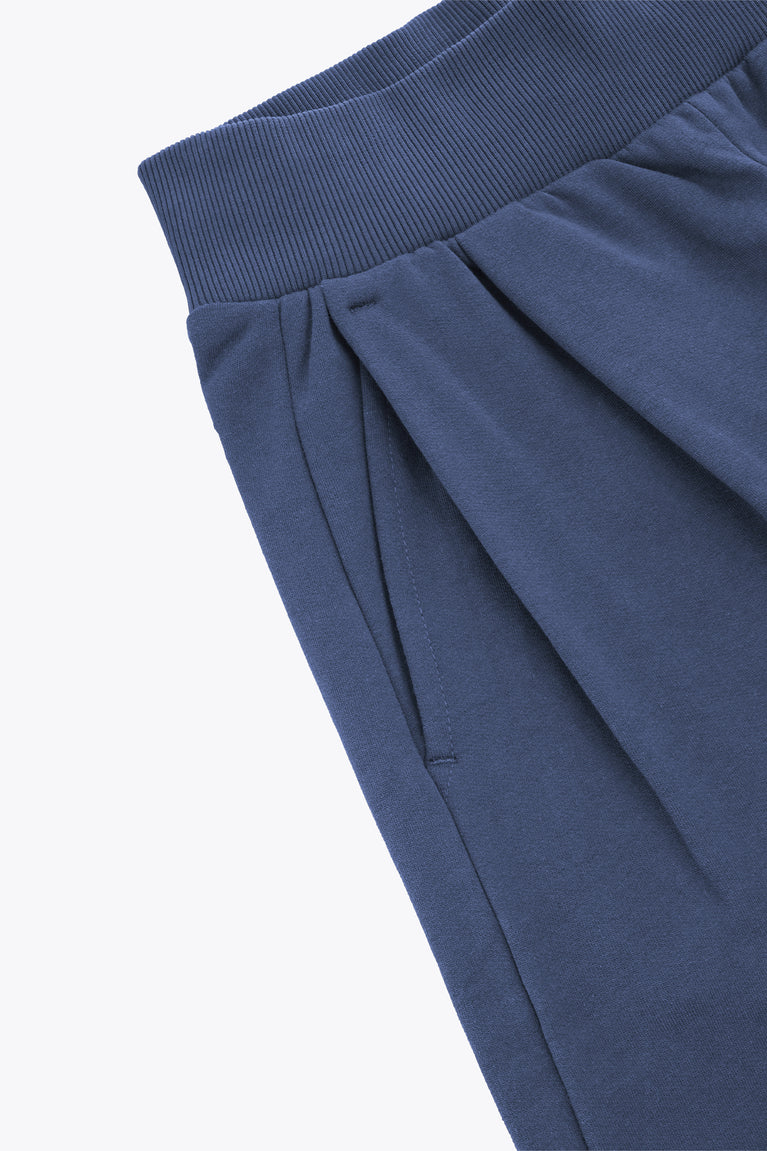 Dark blue wide-leg sweatpants with elastic waistband and draped pleats at the front