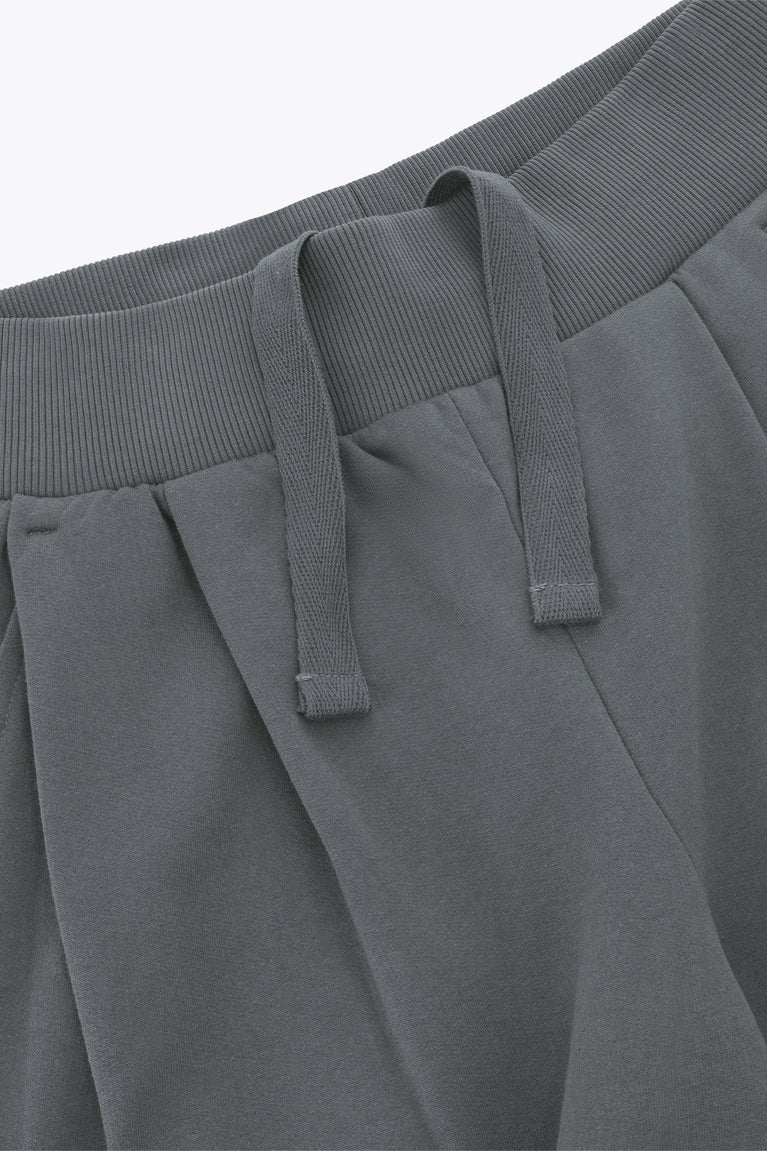 Close-up of grey ribbed waistband and drawstring detail on wide-leg sweatpants