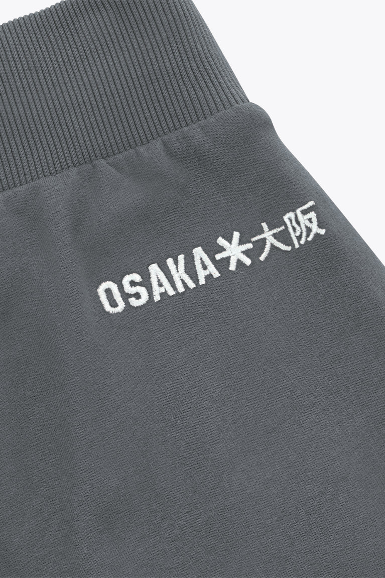 Dark grey sweatpants with white OSAKA logo text print on waistband area