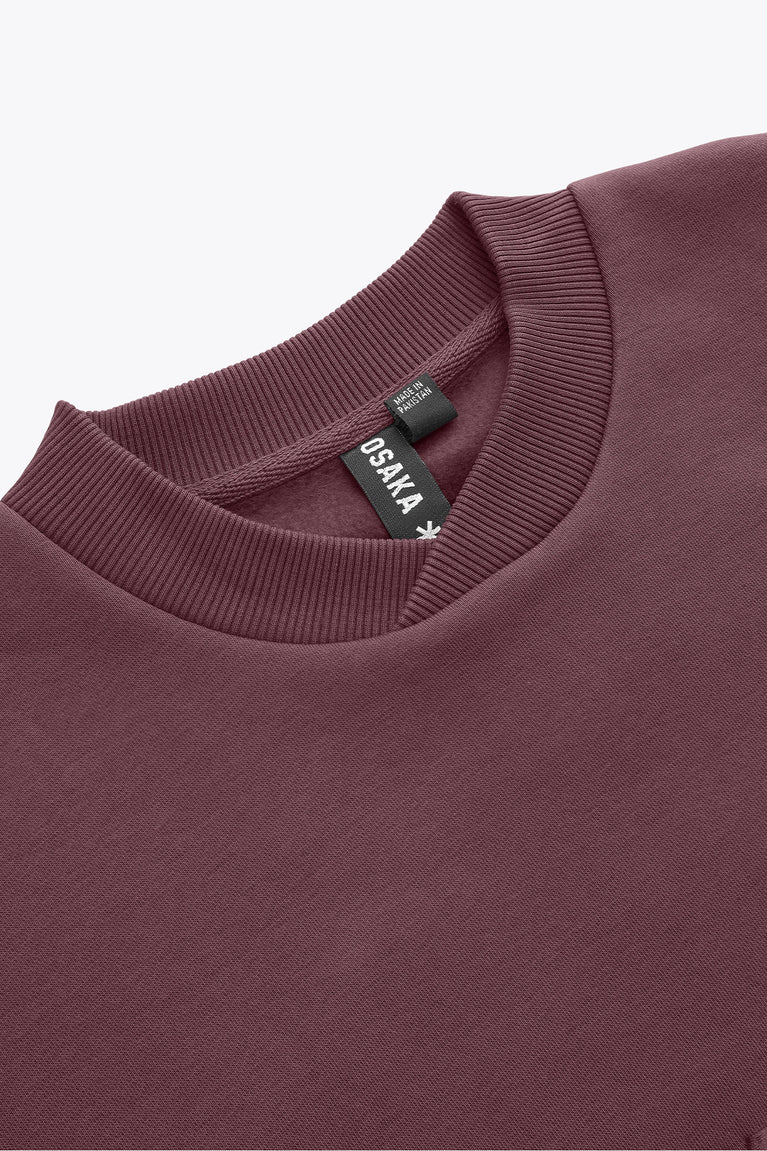 Close-up of men's pullover sweater collar in dark maroon with ribbed crew neckline