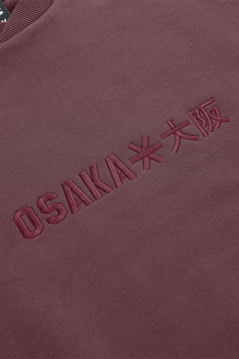 Men's pullover sweater with embroidered OSKAI letters on dark maroon front