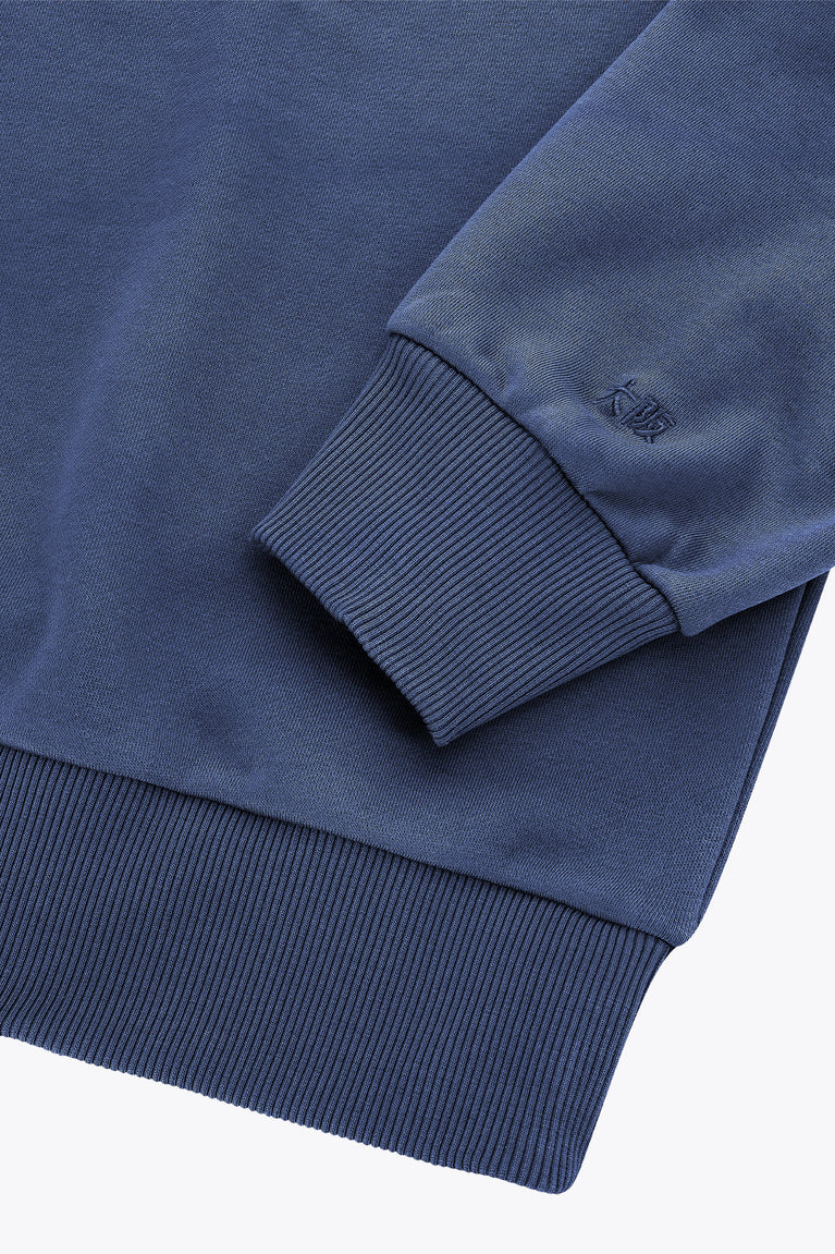 Dark blue sweater sleeve cuff with ribbed knit and small logo detail