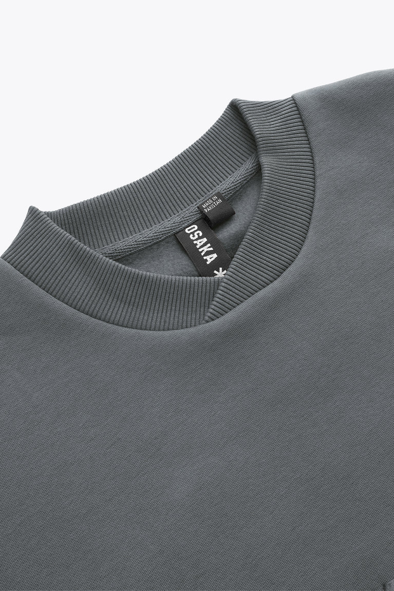 Dark grey sweater neckline with ribbed crew collar and inner logo tag