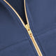 Men's full-zip hoodie zipper close-up, gold-tone tape on dark blue fabric
