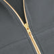 Full-zip hoodie zipper with gold-and-brown patterned tape and curved seam detail