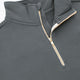 Dark grey half-zip sweater detail with two-tone zipper and raised stand collar