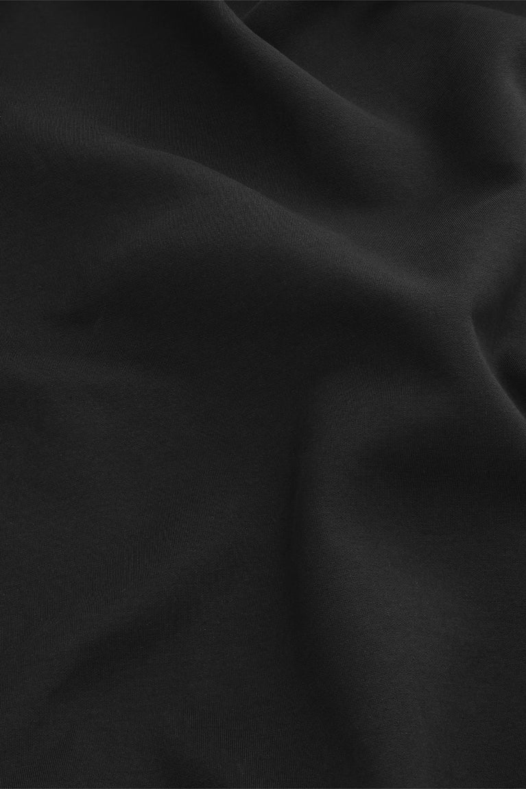 Black unisex hoodie fabric close-up with smooth knit texture.