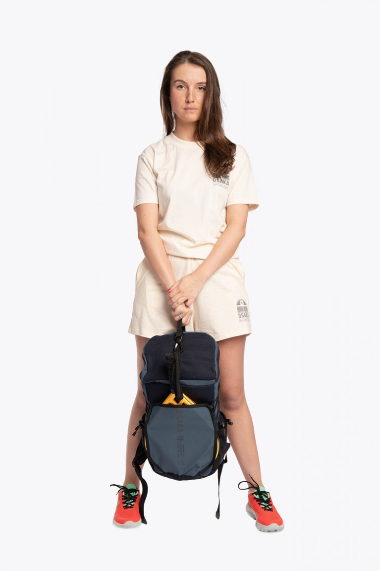  Pro Tour padel backpack in navy with logo in black. Woman holding the bag