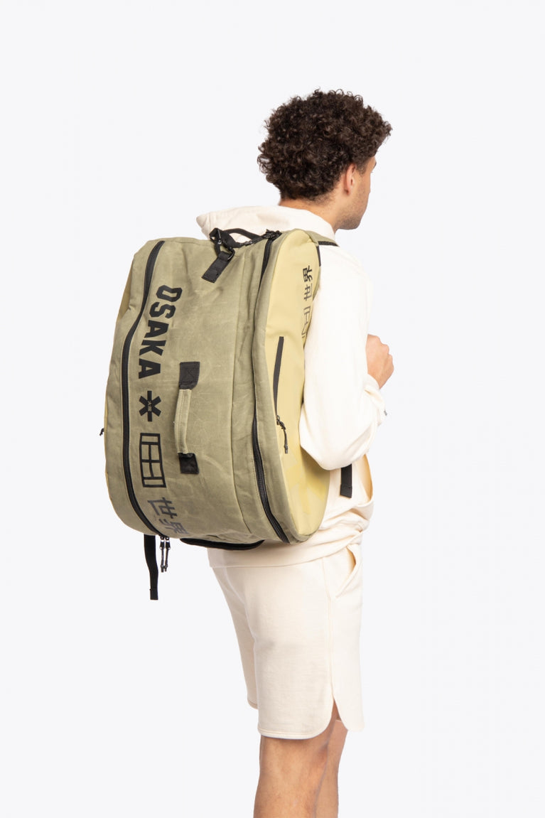 Pro Tour padel bag in olive with logo in black. man wearing the bag back view