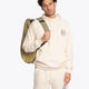 Pro Tour padel bag in olive with logo in black. Man wearing the bag front view
