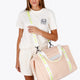Osaka neoprene duffel bag in powder pink with logo in white on the bag and in green on the straps. Woman wearing the bag