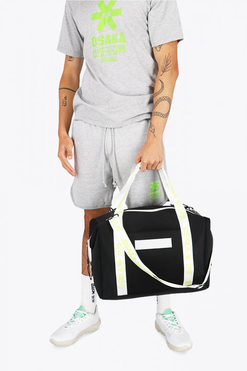Osaka neoprene duffel bag in black with logo in white on the bag and in green on the straps. Front view