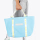 Osaka neoprene Tote bag in light blue with logo in white. Man wearing the bag