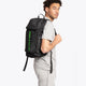 Osaka vision padel backpack in black with logo in green. Man wearing the bag side view