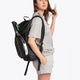 Osaka vision padel backpack in black with logo in green. Woman wearing the bag side view