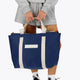 Osaka neoprene Tote bag in navy with structure and logo in white. Woman holding the bag