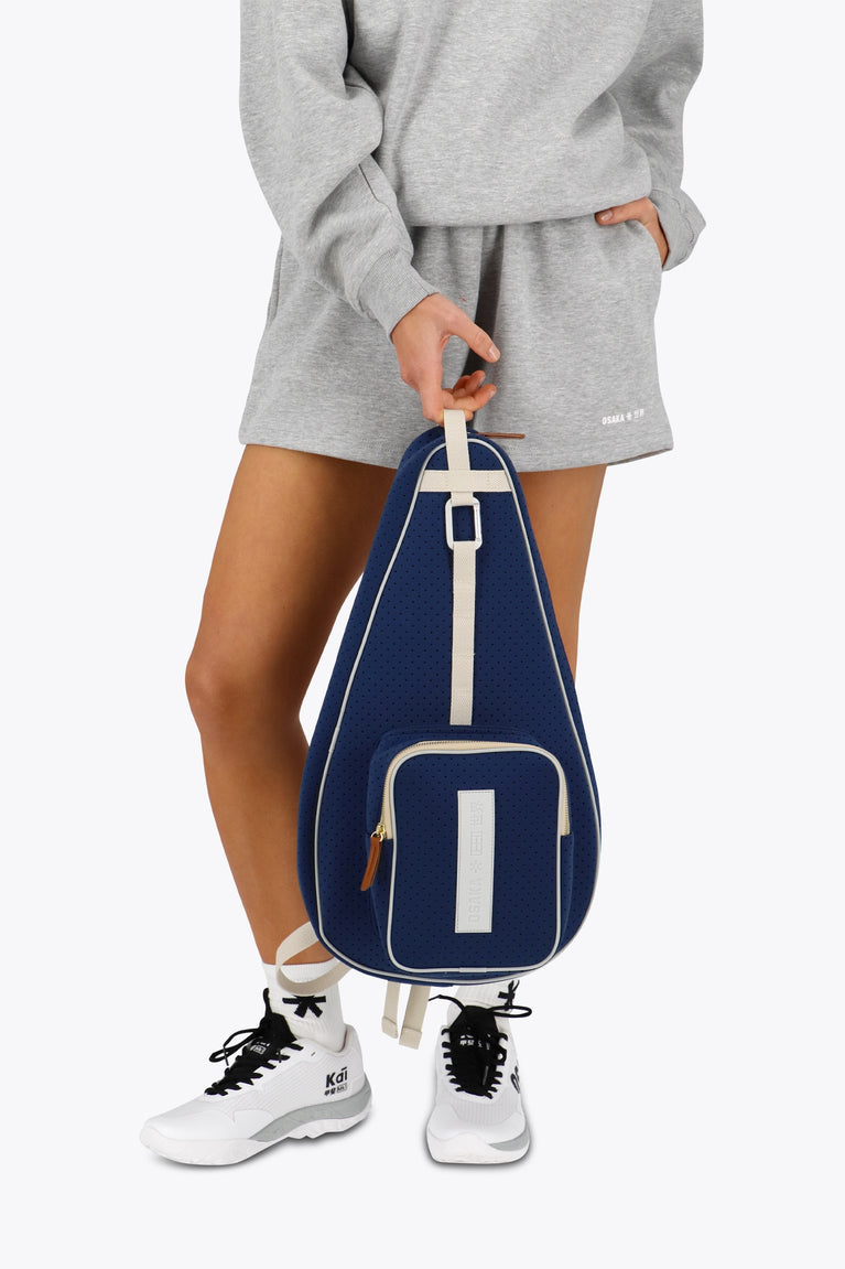 Osaka neoprene padel bag in navy with structure and logo in white. Woman holding the bag
