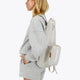Osaka neoprene padel bag in light grey with structure and logo in white. Woman wearing the bag