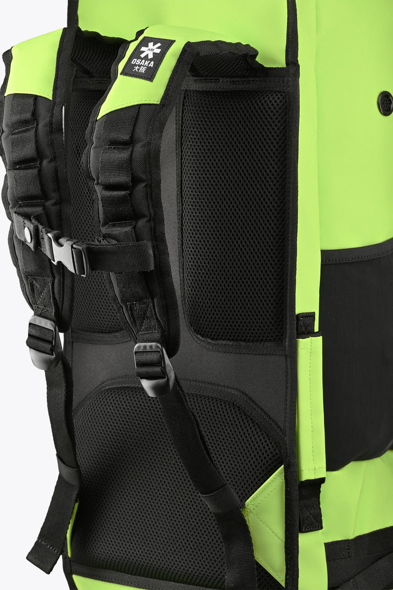 Padded black shoulder straps on a wild lime Osaka stickbag with mesh back panel