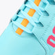 Light blue sneaker upper with orange lace-strap details and stitched overlays