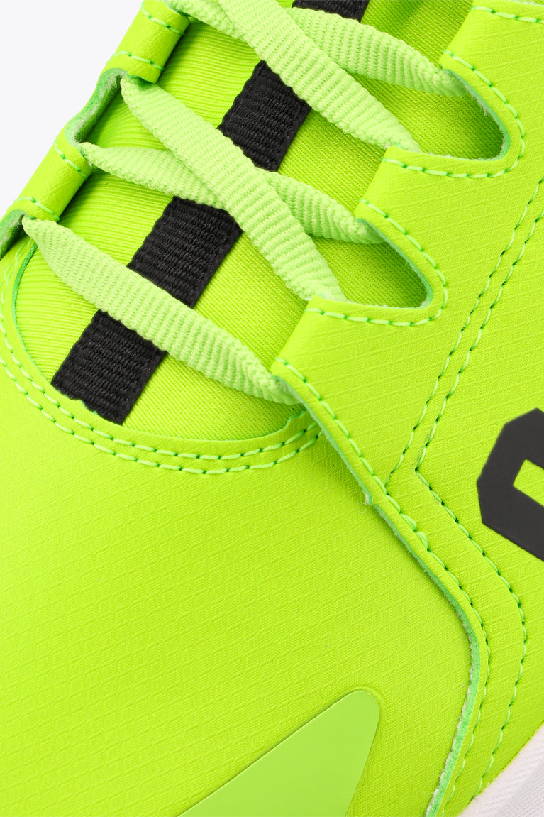Neon lime lace-up sneaker close-up with black lace blocks and stitching