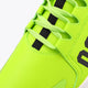 Lime green lace-up sneaker upper with black strap accents and stitched toe