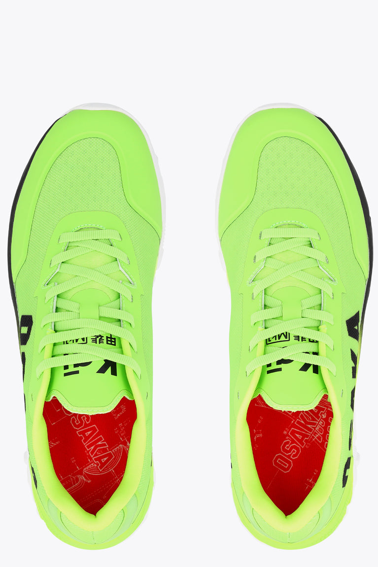 Lime green sneakers with lace-up and red inner lining, front view