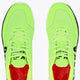 Lime green sneakers with lace-up and red inner lining, front view