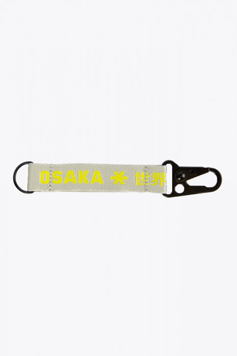 Osaka keychain in light grey with logo in yellow