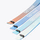Three multicolor Yibbi fabric bracelets with elastic ends, angled close-up